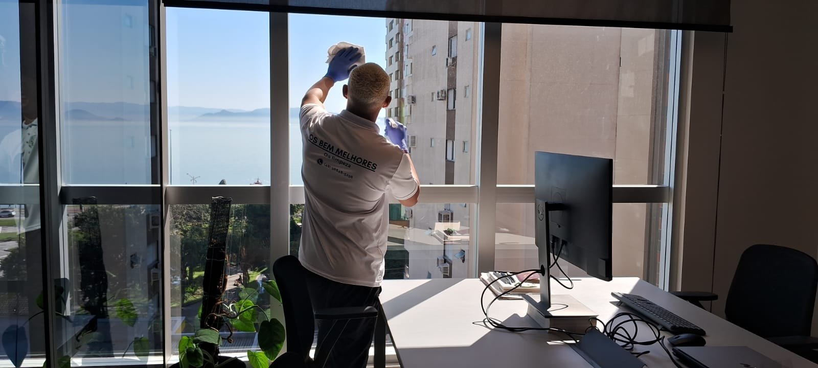 Profissional limpando vidros em escritório